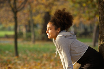 Poster - Young woman smiling and resting after workout in the park