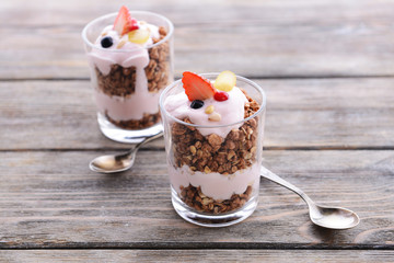 Healthy layered dessert with muesli and berries on table