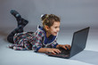 © maxximmm - baby girl playing laptop on gray background