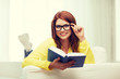 © Syda Productions - smiling teenager reading book and sitting on couch