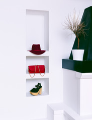 Women's fashion accessories in white interior. Hat, clutch and s