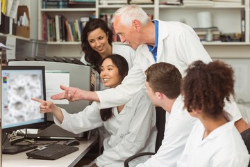 Wall Mural - science students looking at microscopic image on computer