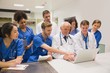 © WavebreakMediaMicro - Medical students and professor using laptop