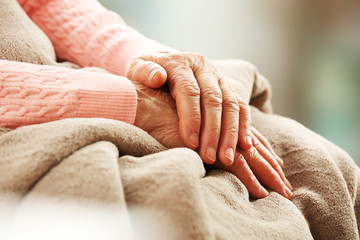 Wall Mural - Hands of adult woman on light background, closeup