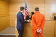 © WavebreakMediaMicro - Lawyer and judge speaking next to the criminal in handcuffs