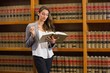 © WavebreakMediaMicro - Pretty lawyer reading in the law library