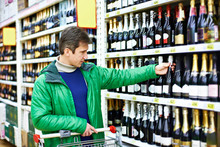 Man Choosing Wine In Supermarket