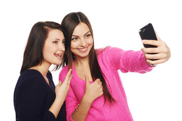 Two girls friends taking selfie with smartphone