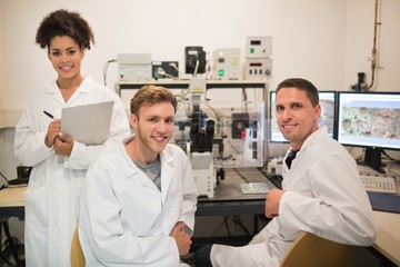Wall Mural - biochemistry students using large microscope and computer