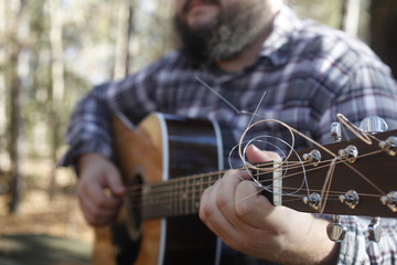 A folk country musician playing his guitar.