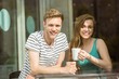 © WavebreakmediaMicro - Smiling friends holding mug of coffee
