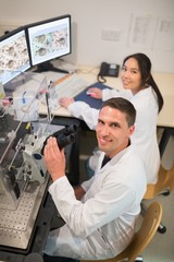 Wall Mural - biochemistry students using large microscope and computer