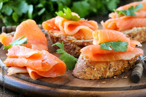 Fotografie, Obraz Smoked salmon free canape parsley leaf on wood