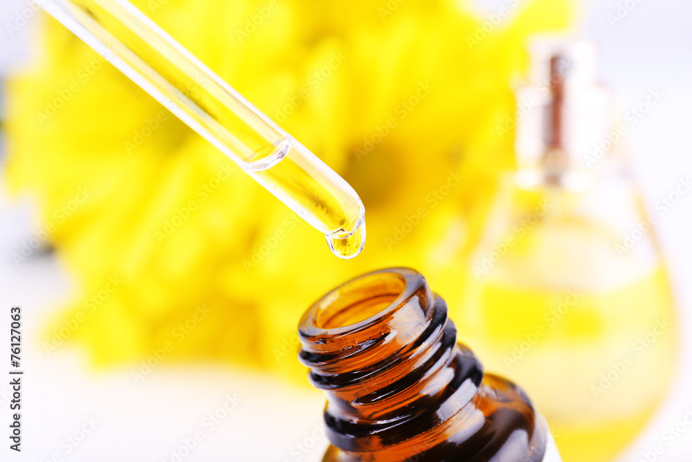 Dropper bottle of perfume with yellow chamomile