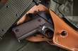 Colt pistol in holster and belt lie on military jacket