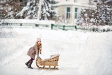 Little Girl Playing With Vintage Sleds In Winter