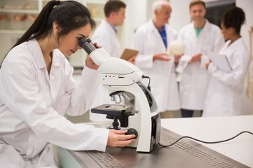 Wall Mural - young medical student working with microscope
