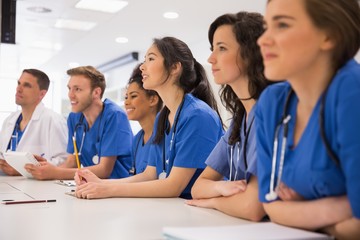 Medical students listening sitting at desk