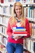 © WavebreakMediaMicro - Mature student in library holding books