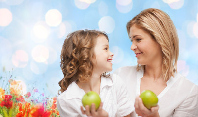 Wall Mural - happy mother and daughter with green apples