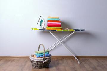 Wall Mural - Ironing board with laundry on light background