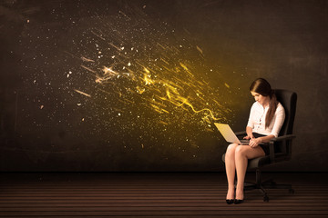 Wall Mural - Businesswoman with laptop and energy explosion on background