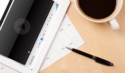 Wall Mural - tablet pc showing media player on screen with a cup of coffee on