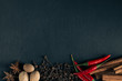 Herbs and spices on black background with space for text.