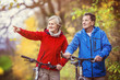 © Halfpoint - Active seniors walking with bike