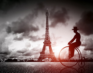 Wall Mural - Man on retro bicycle next to Effel Tower, Paris, France.