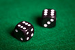 © Syda Productions - close up of black dice on green casino table