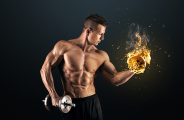 Wall Mural - Muscular man with dumbbells on dark background