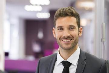 Wall Mural - Portrait of smiling Businessman posing  in modern office