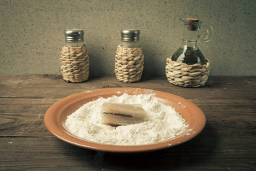 Wall Mural - Pepper, salt, olive oil and one piece of fresh fish with flour o