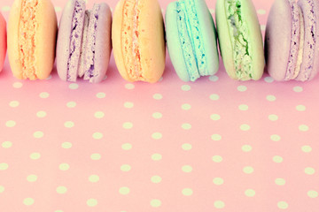 Wall Mural - Tasty macaroons on pink polka dot background