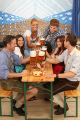 Canvas Print - Gruppe in Trachtenkleidung mit Maßkrügen im Bierzelt