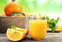 Glass Of Orange Juice With Crate Of Oranges And Slices