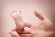 Baby Feet In Mans Hand