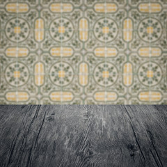 Wood table top and blur vintage ceramic tile pattern wall