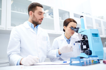 Poster - scientists with clipboard and microscope in lab