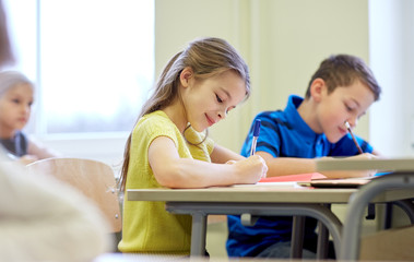 Canvas Print - group of school kids writing test in classroom