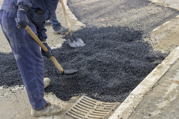 asphalt workers with shovels patching asphalt 2