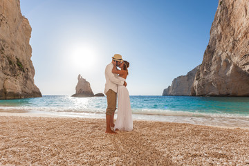 Wall Mural - Beautiful young couple at the beach kissing 