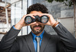 © Minerva Studio - Businessman using binoculars, people portraits in the lens