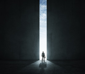 Lonely businessman standing in front of the huge gate