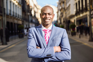 handsome black man wearing suit in urban background