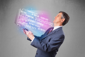 Businessman holding notebook with exploding data and numbers