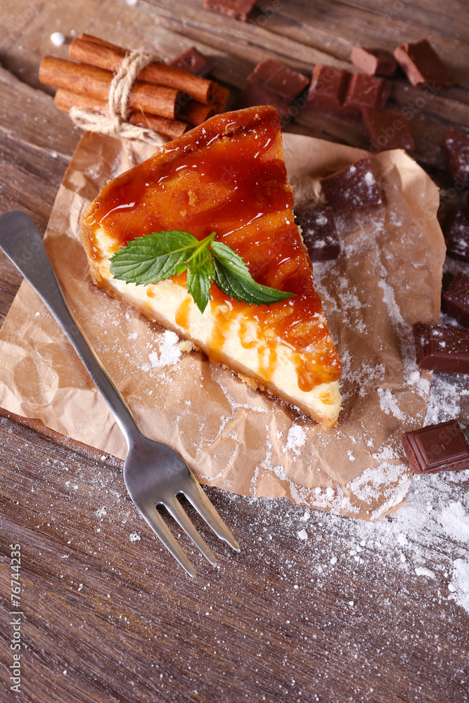 Cheese cake with sugar powder on paper on wooden background