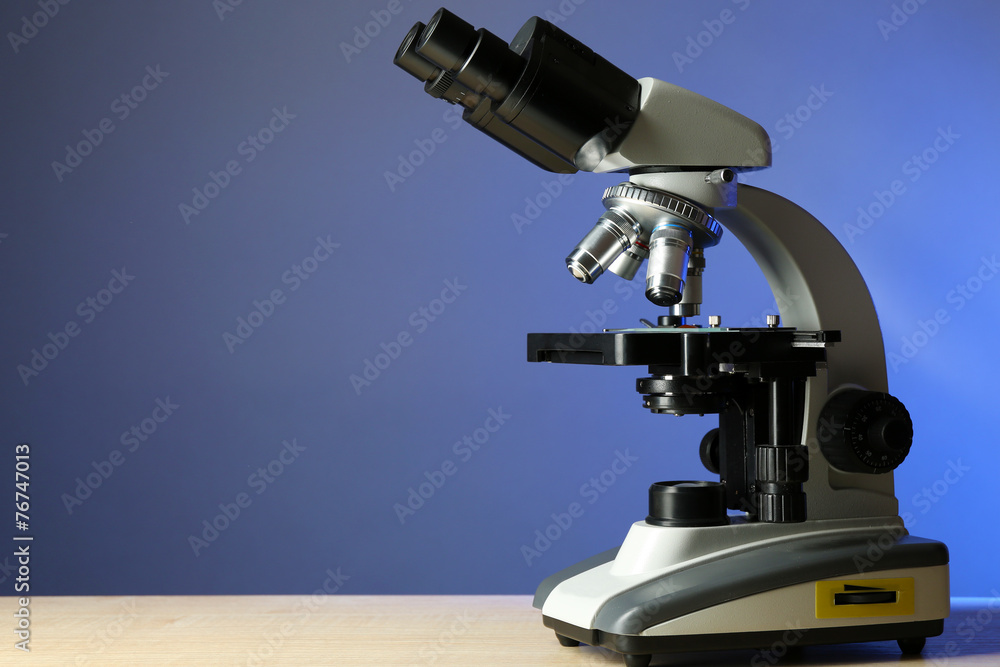 Microscope on table, on color background
