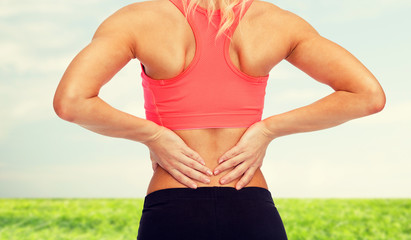 Wall Mural - close up of sporty woman touching her back